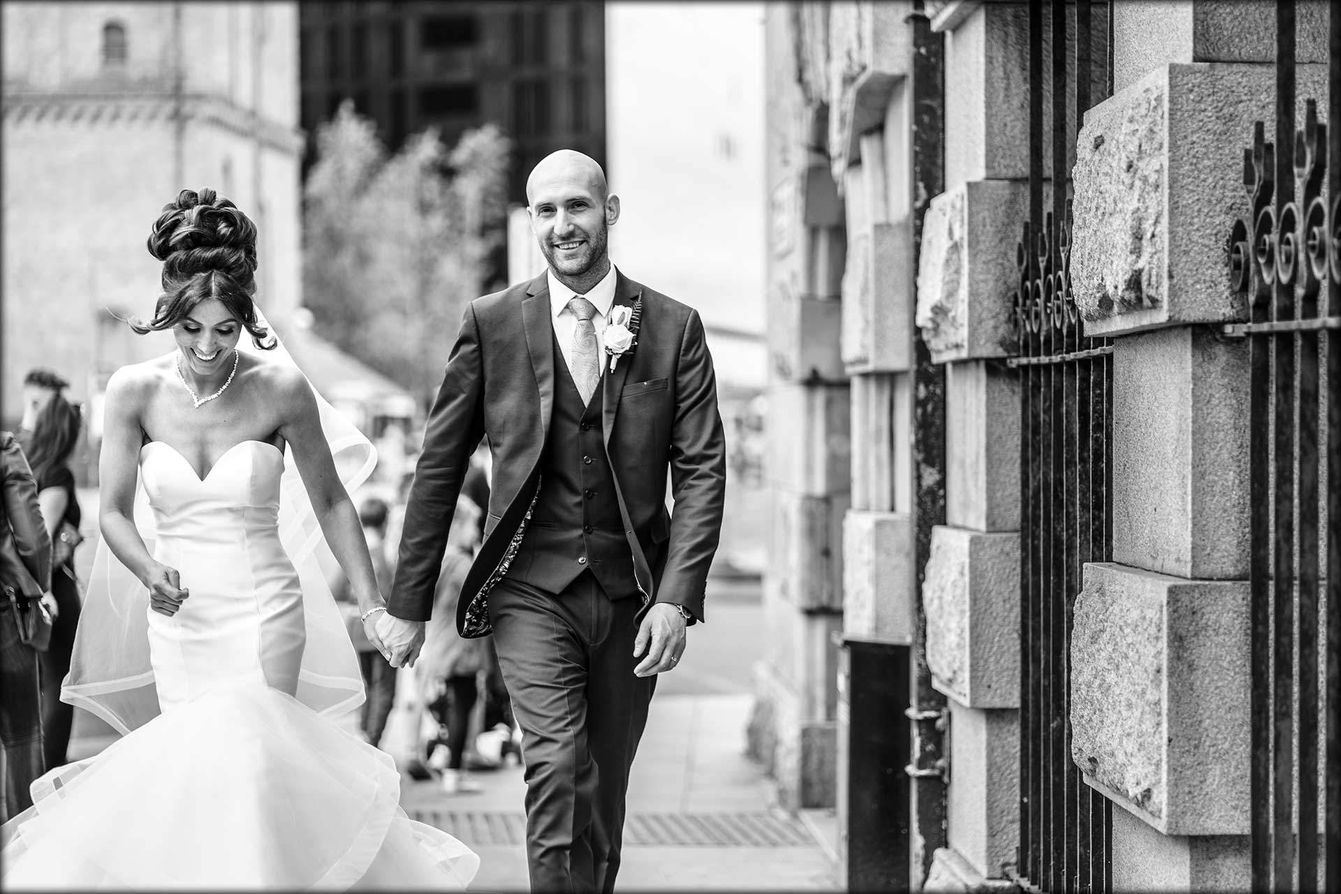 bride and groom walking through Liverpool