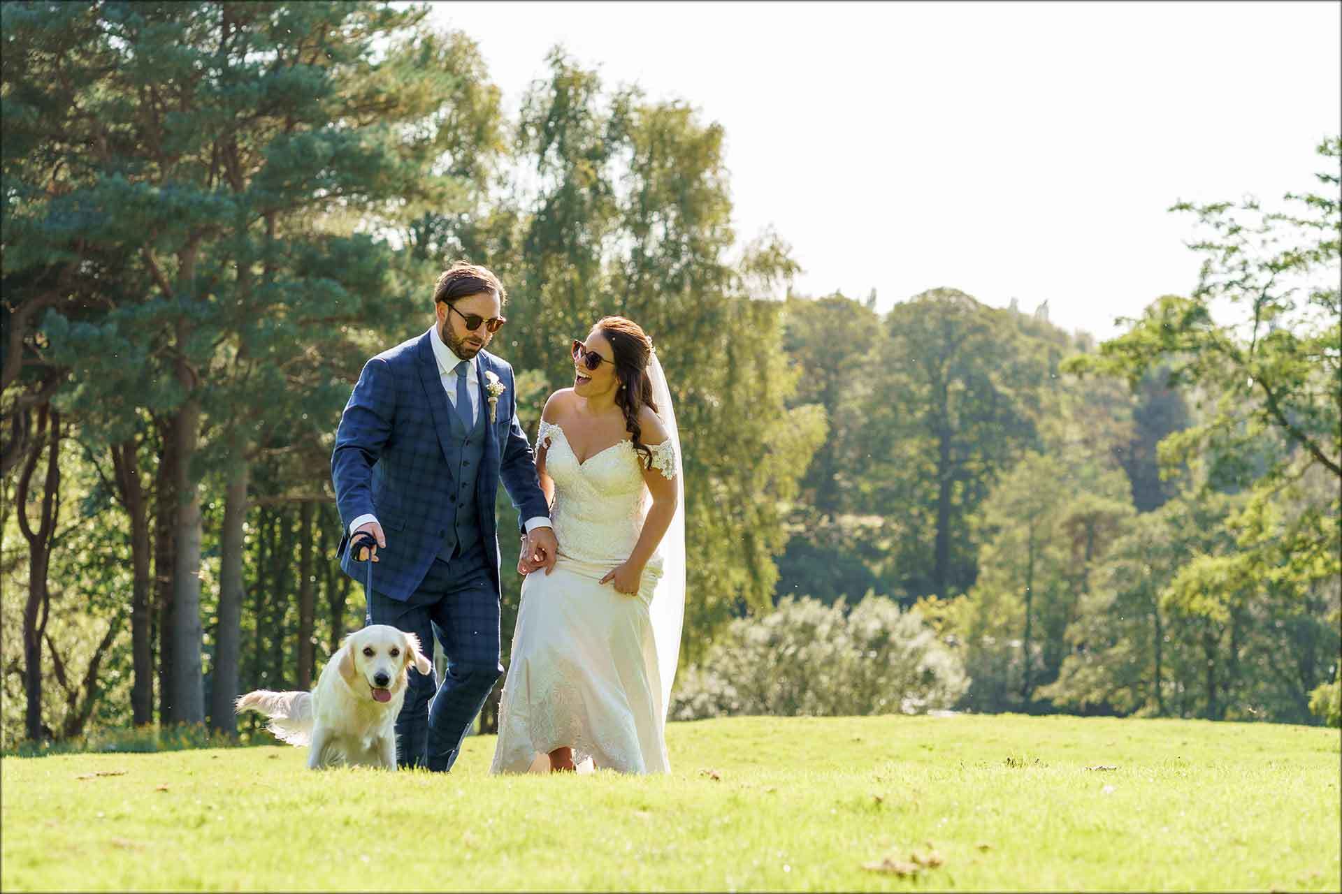 Bride and groom walking the dog